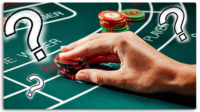 Hand Placing Poker Chips on Baccarat Table, Question Marks