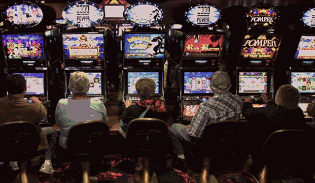 Row of People Playing Slot Machines