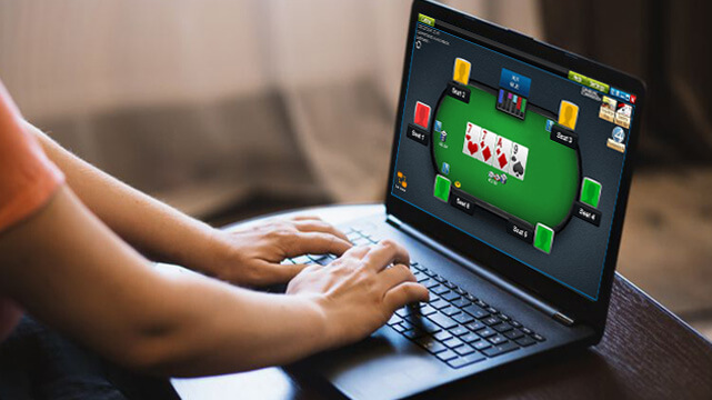 Person on Laptop Playing Online Poker Game