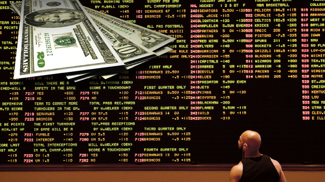 Guy Looking Over Sports Betting Board, Money Spread Out