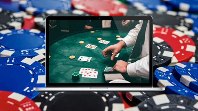 Pile of Casino Chips, Laptop Displaying Dealer at Blackjack Table