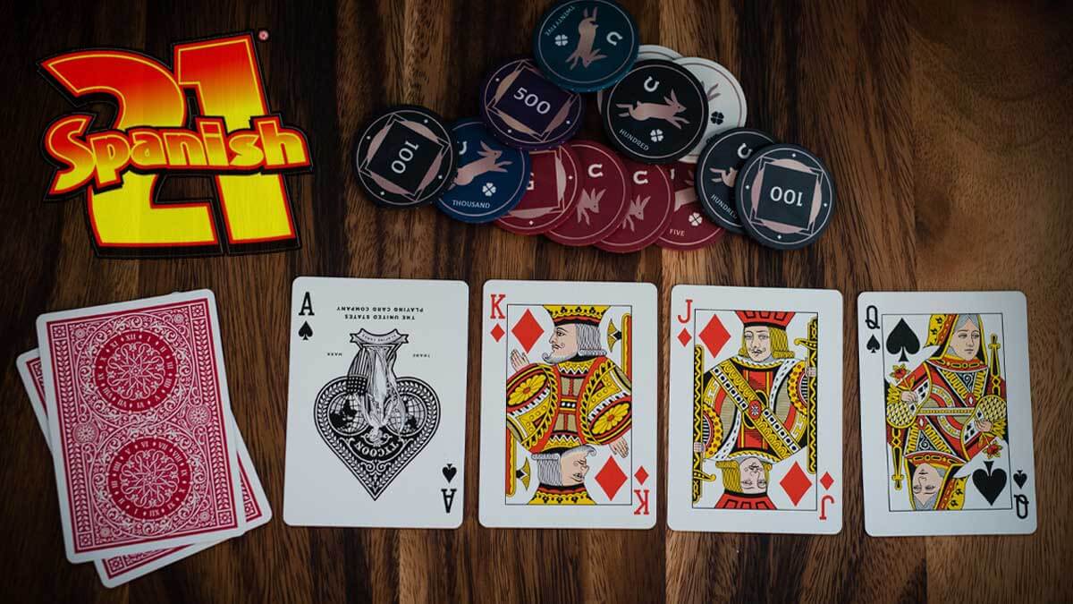 Four Blackjack Cards Next to Deck on Table, Casino Chips, Spanish 21 Logo