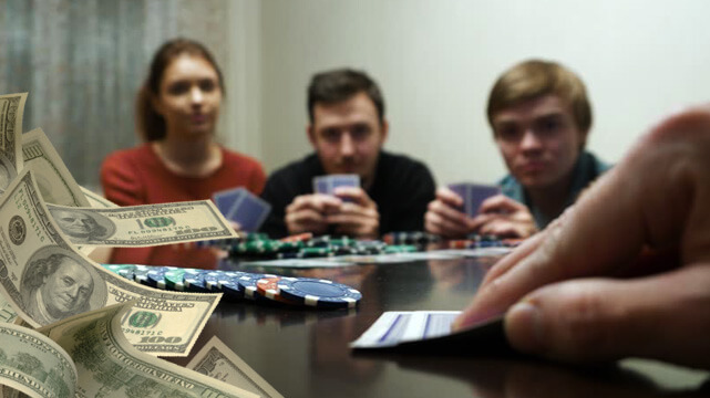 Friends at Home Playing Poker, Holding Poker Cards and Casino Chips, Money