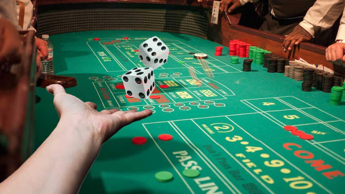 Hand Throwing Dice on Craps Casino Table