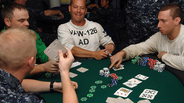 Group of Men Surrounding Poker Table Playing Poker
