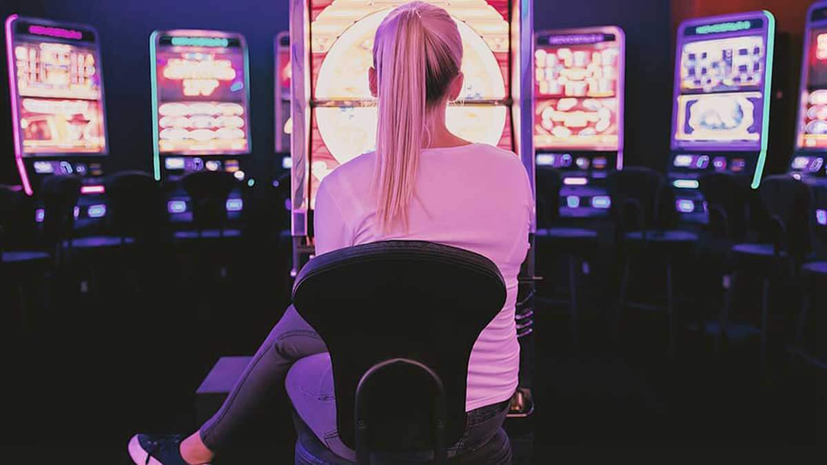 Woman Sitting Playing Slot Machine at the Casino
