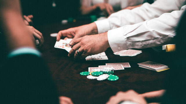 Casino Dealer Moving Blackjack Cards on Table
