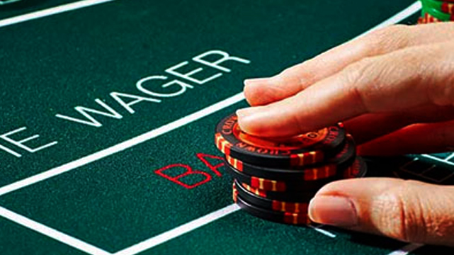 Closeup of Hand Betting Chips on Baccarat Table