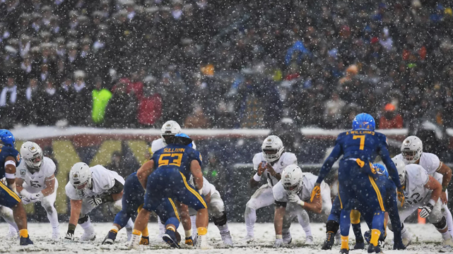 College Football Players Playing Game in Snow