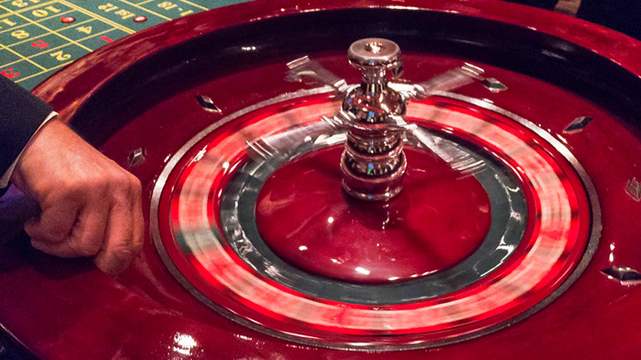 Closeup of a Hand Spinning a Roulette Wheel