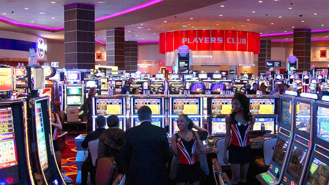 Slot Machines With Players Card Desk in Background