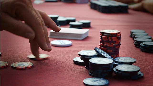 Closeup of Hand Reaching for Poker Chips