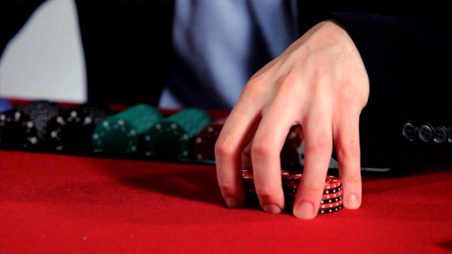 Closeup of Man With Hand Over Casino Chips