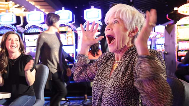 Excited Woman Playing Slots at Saracen Casino Resort