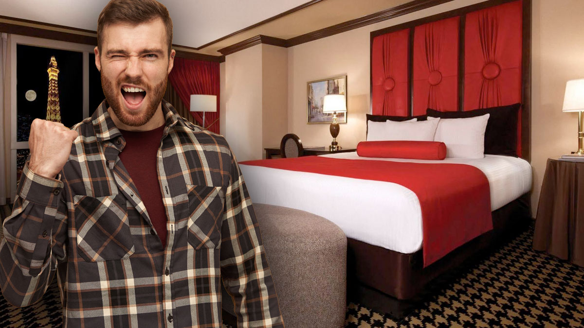 Man With Fist In Air in Excitement With Hotel Room in Background 