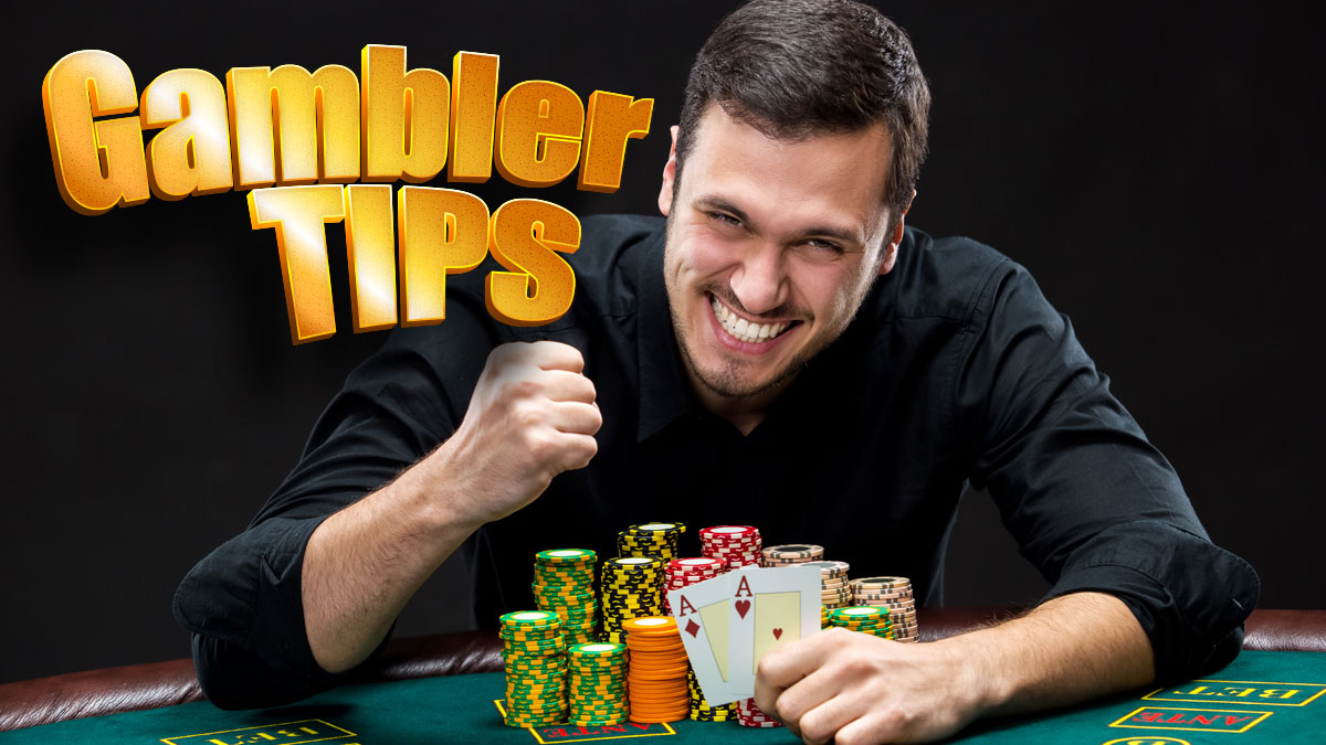 Excited Man Holding Poker Cards With a Pile of Casino Chips in Front of Him