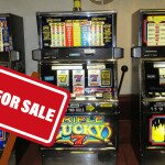 Row of Slot Machines with a For Sale Sign in Front