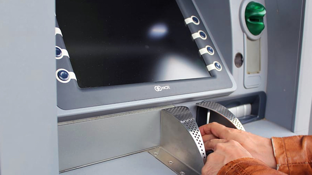 Man Taking Money Out of an ATM Machine