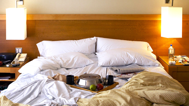 Tempat Tidur Hotel Berantakan Dengan Tempat Makan Dalam Kamar