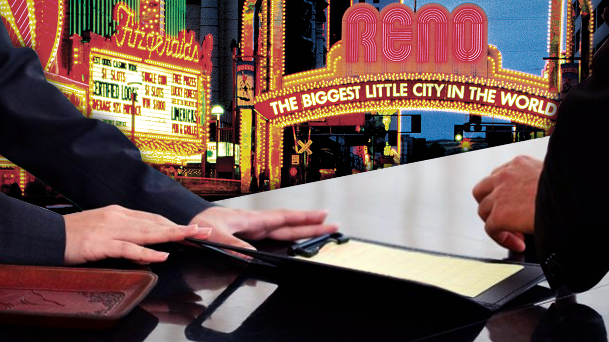 Front Desk Clerk Handing Over a Bill With a Reno Background