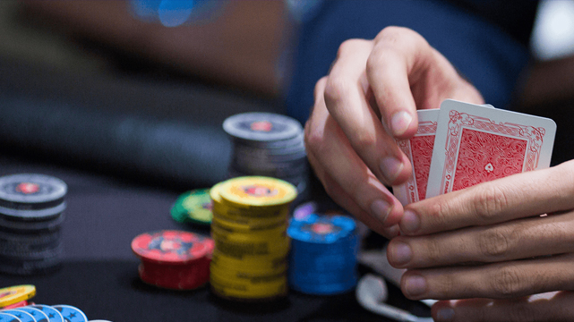 Tampilan jarak dekat dari Pemain Poker yang Memegang Kartu Mereka