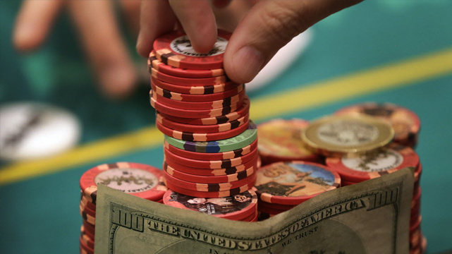 Tumpukan Keripik Poker dan Uang Seratus Dolar