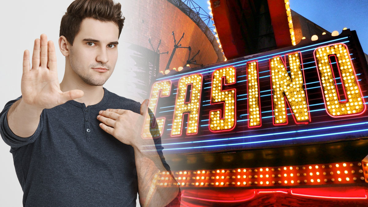 Man With Hand Up In Front of a Casino Sign on Left